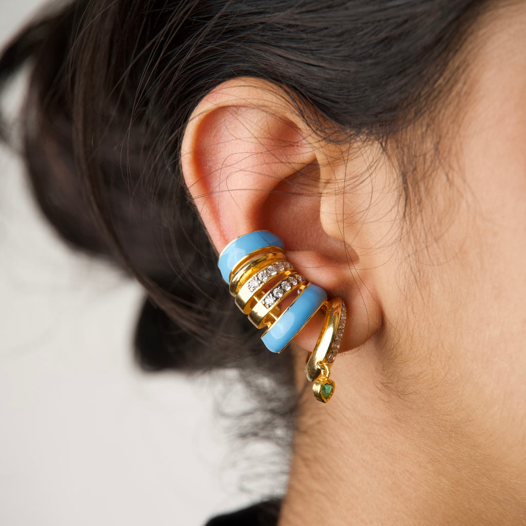 Capri Ear Cuffs — blue enamel gold ear cuff with emerald heart drop, worn on ear