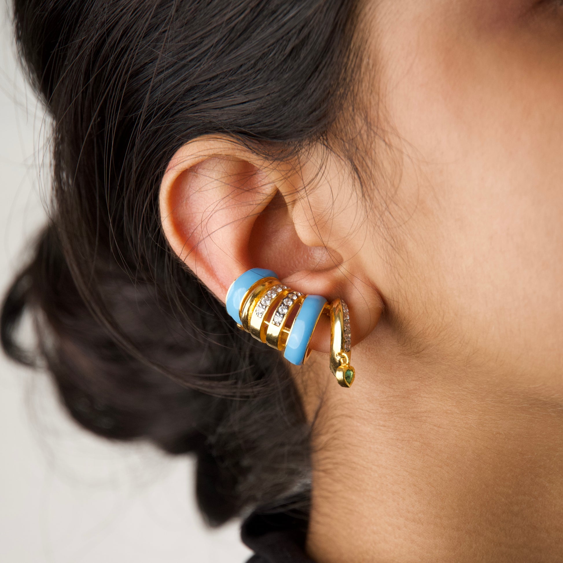 Capri Ear Cuffs — blue enamel gold ear cuff with emerald heart drop, worn on ear