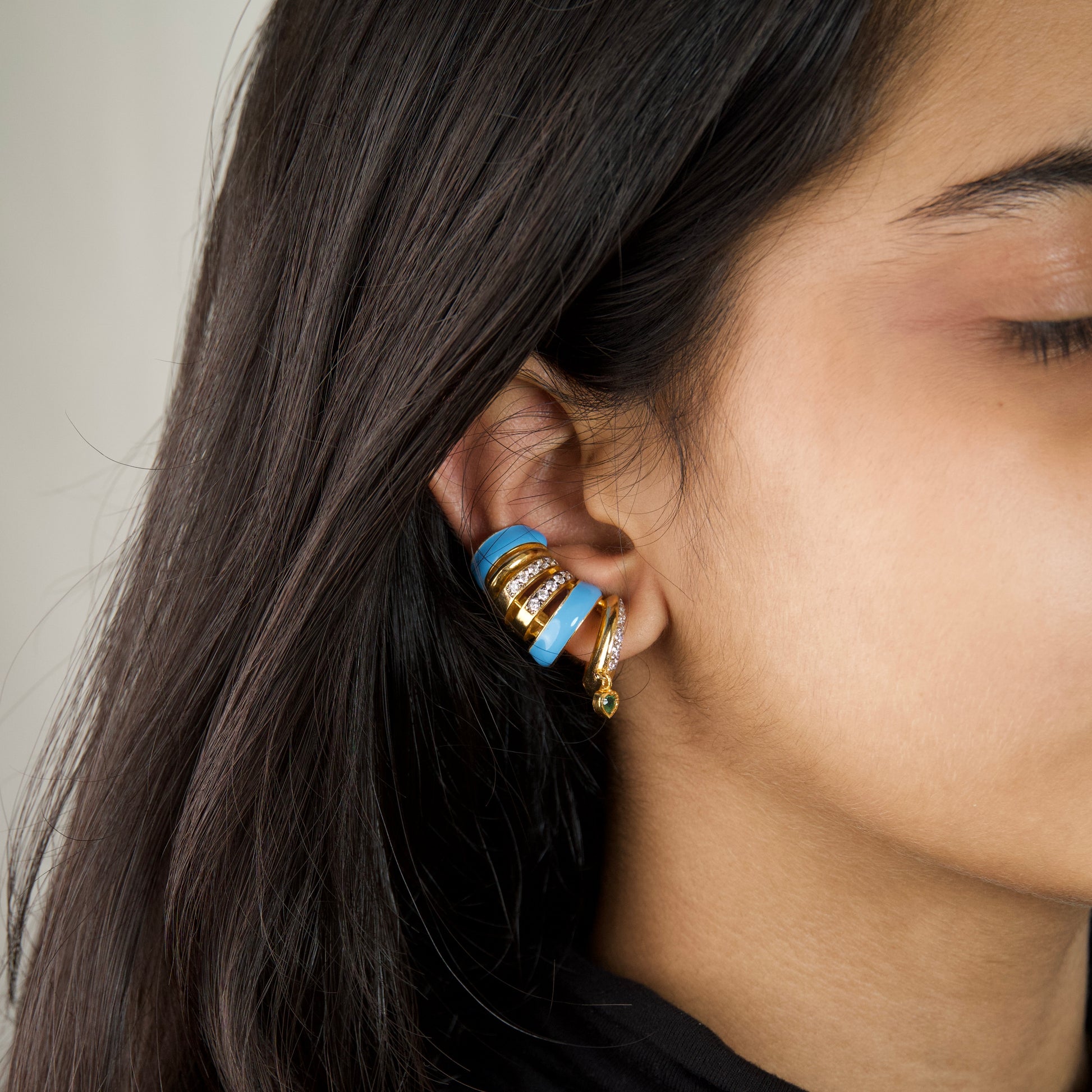 Capri Ear Cuffs — blue enamel gold ear cuff with emerald heart drop, worn on ear