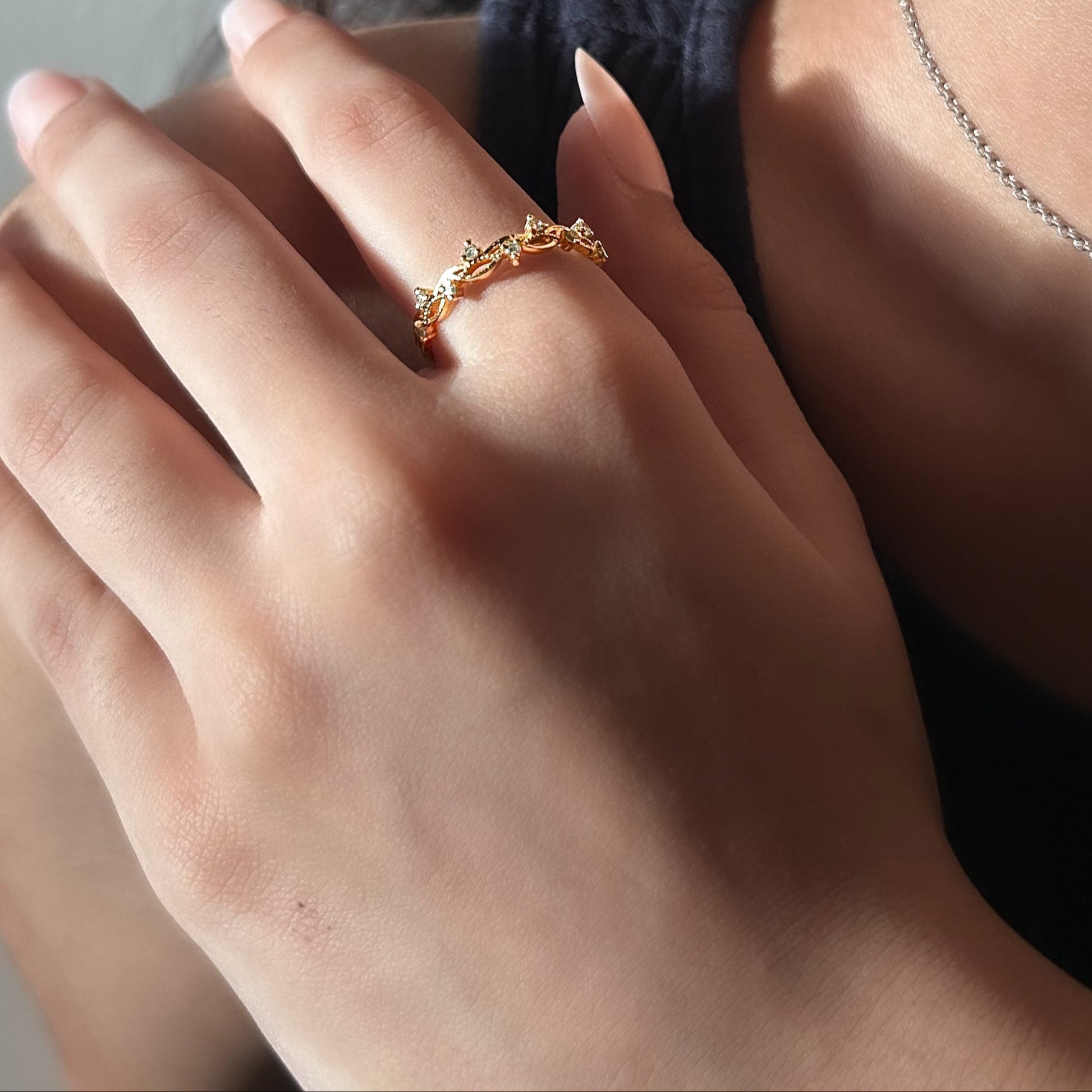 Close-up of a hand wearing a gold ring with a blurred background