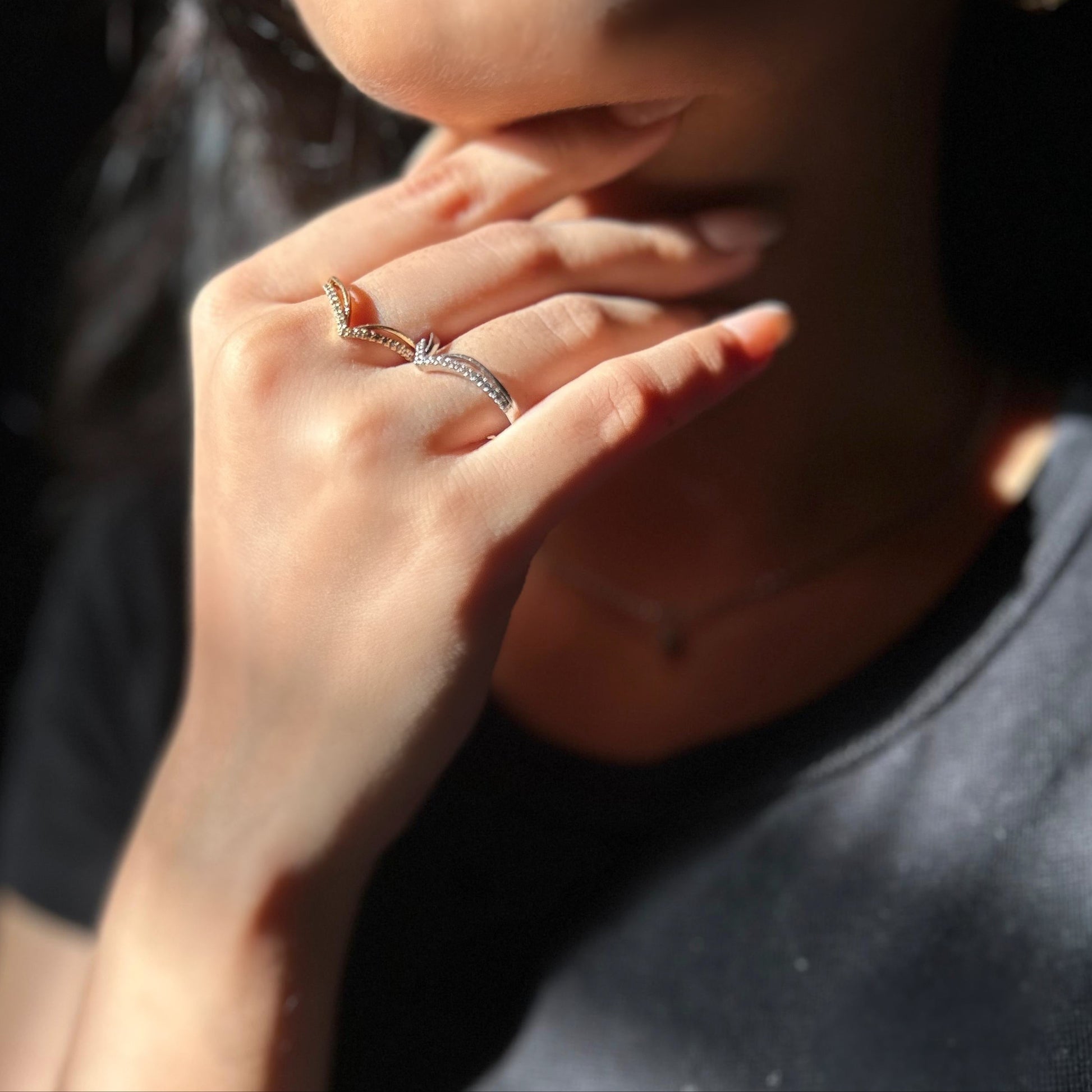 Close-up of a person wearing a ring with a dark background