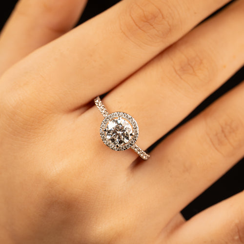 Adele ring worn on hand — round centre stone with diamond halo on a pave band