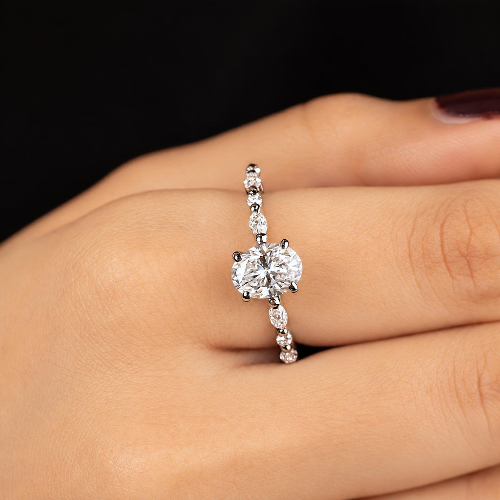 Arabella ring worn on hand — oval solitaire on a mixed marquise and round pave band