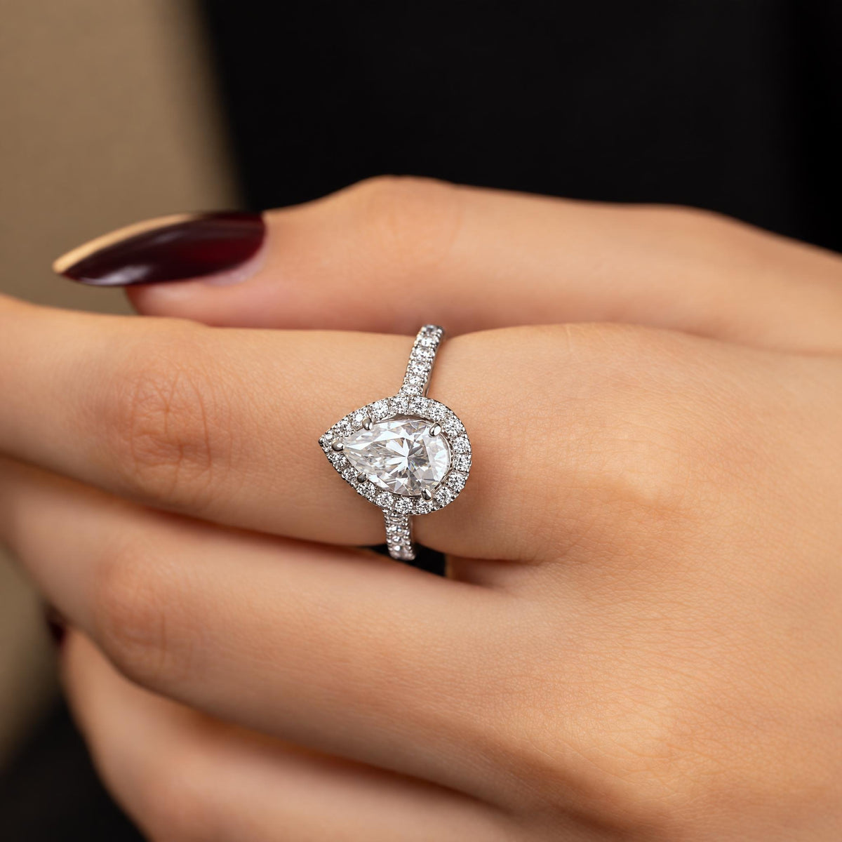 Katerina ring worn on hand — pear-cut solitaire with diamond halo on a pave band