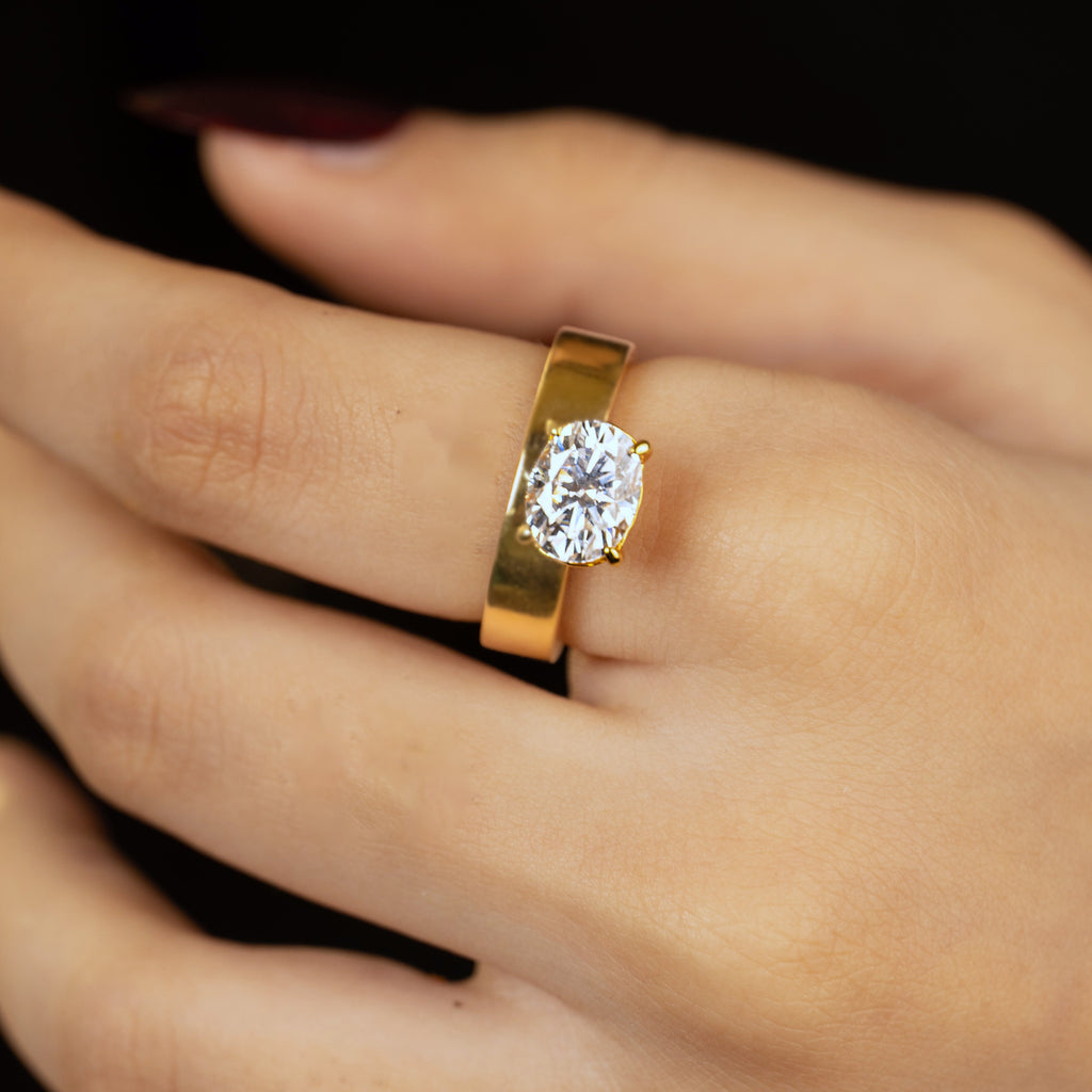 Sloane ring worn on hand — oval stone set offset on a thick gold band