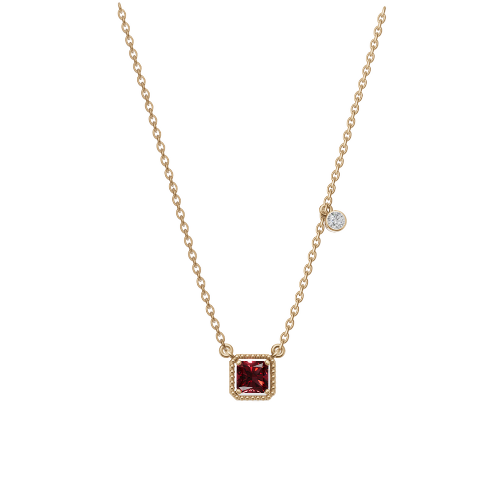 Gold necklace with a red gemstone pendant on a light gray background